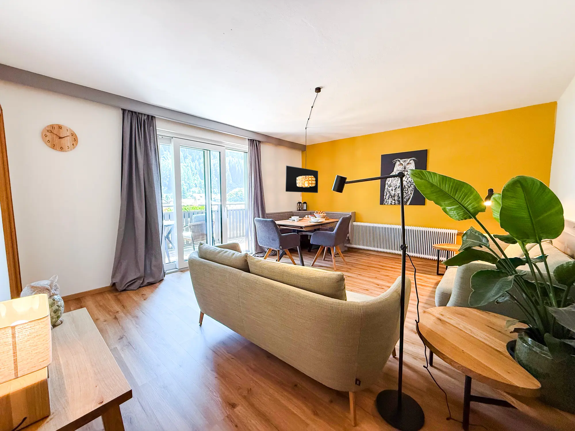 Weites Wohnzimmer der Ferienwohnung Eule mit Sitzecke, Essplatz und Balkontür