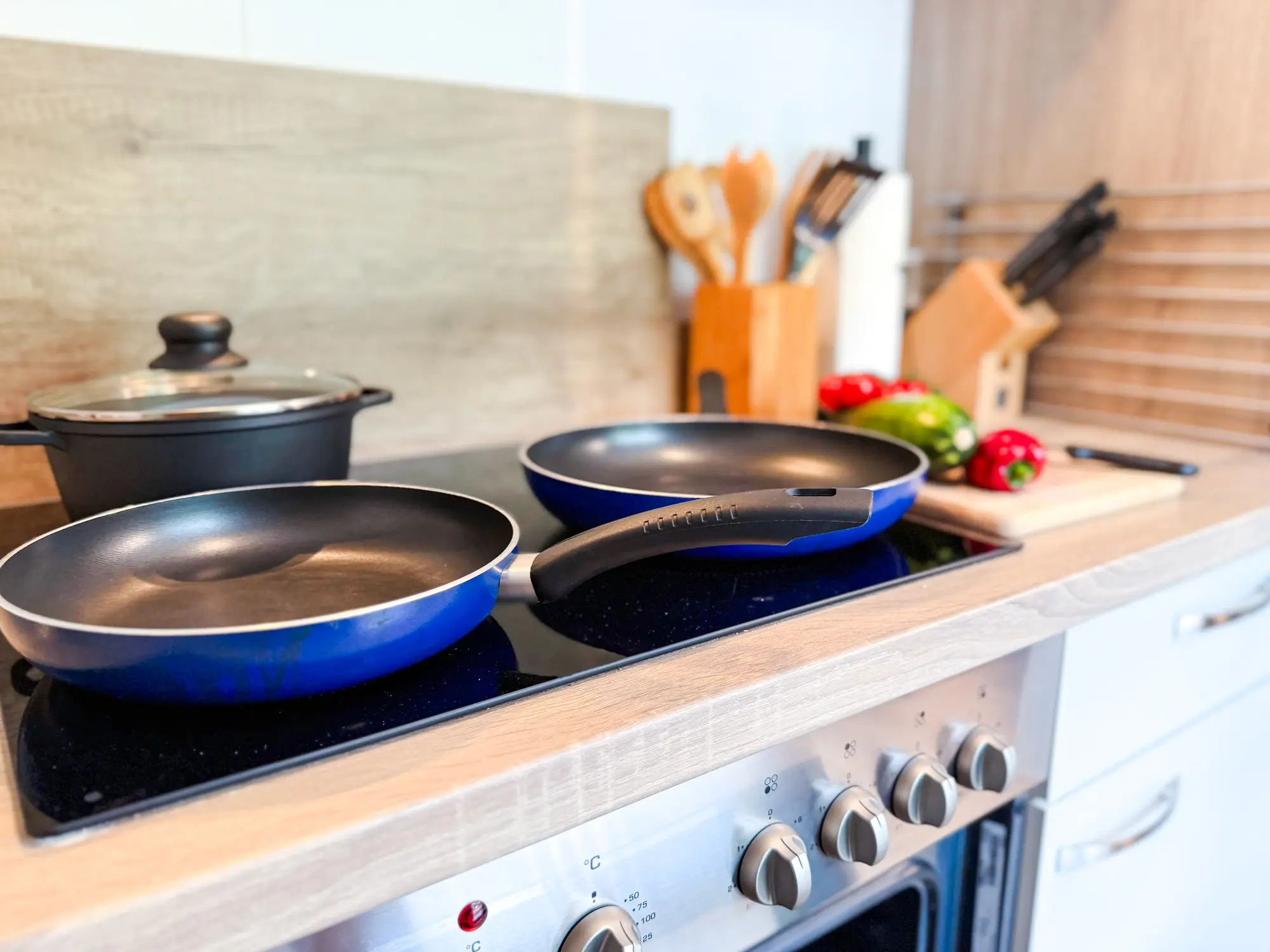 Keramische kookplaat met pannenset in de keuken van Eule