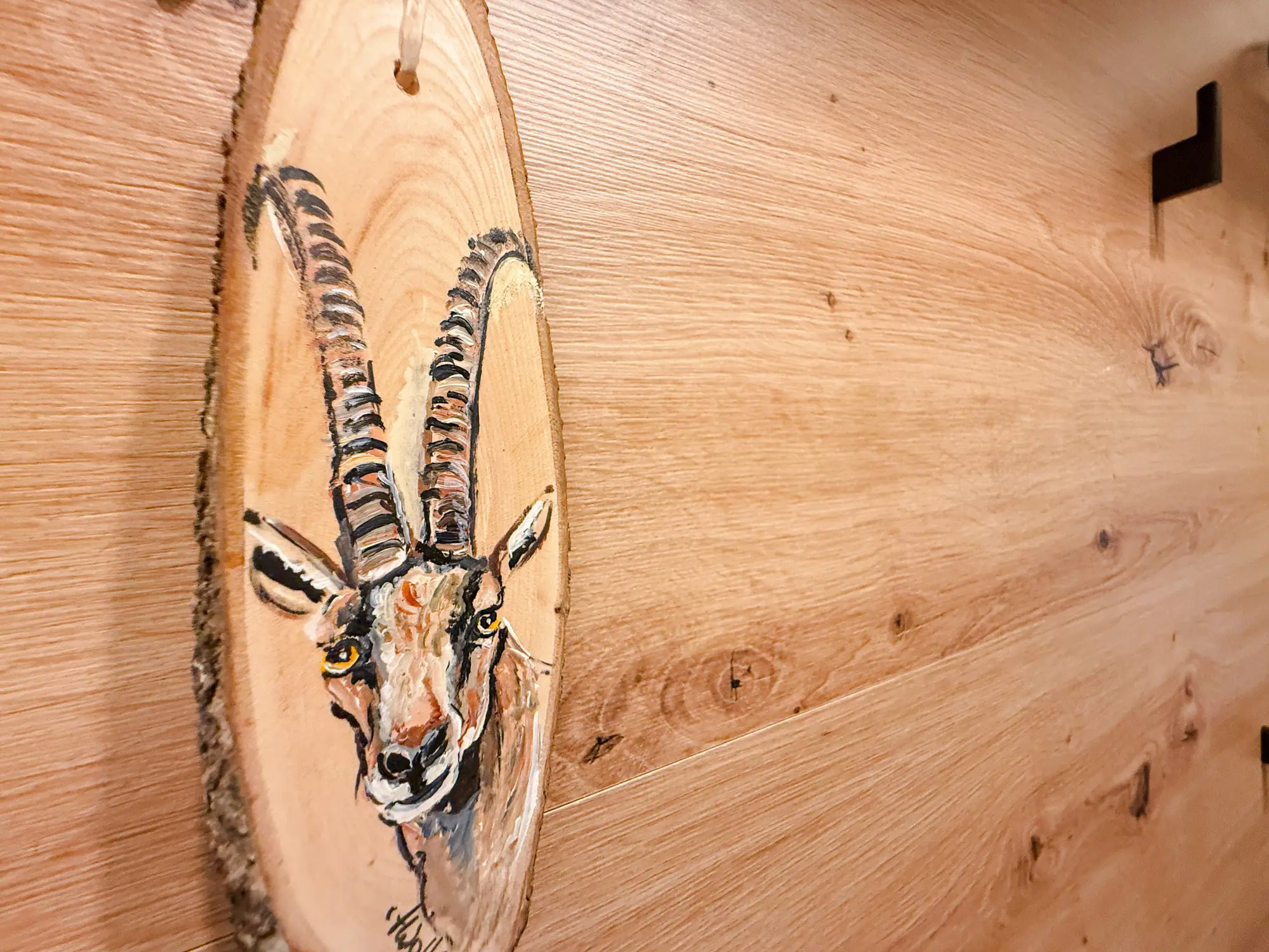Handgeschilderde steenbok op hout, de naamgever van het appartement