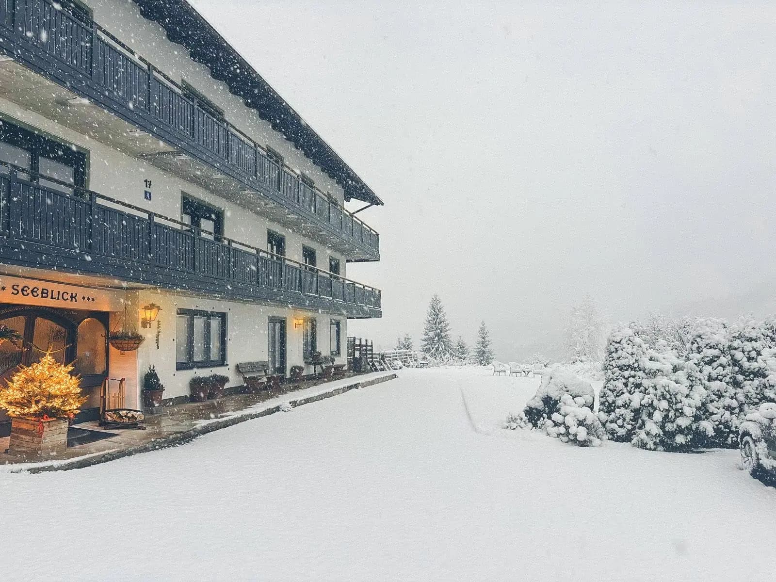 Das Berghaus Seeblick im Schneefall, frischer Schnee rund um das Haus und Licht hinter den Fenstern