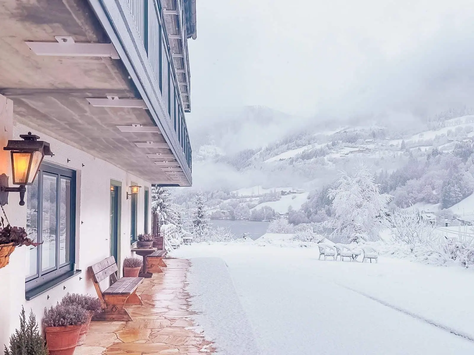 The terrace of Berghaus Seeblick in the snow, lantern lit